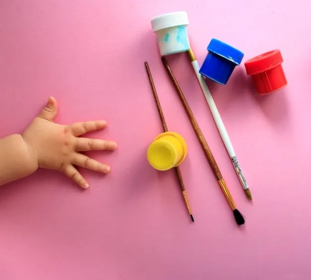 Close-up shot of a child's hands mixing different colors of paint on a palette with a paintbrush.