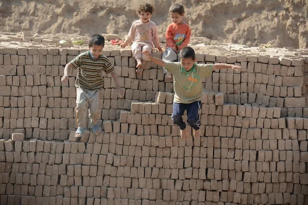 A group of children are enthusiastically working together to build a large structure out of interlocking building blocks. The structure is colorful and complex, showcasing their collaborative engineering skills.