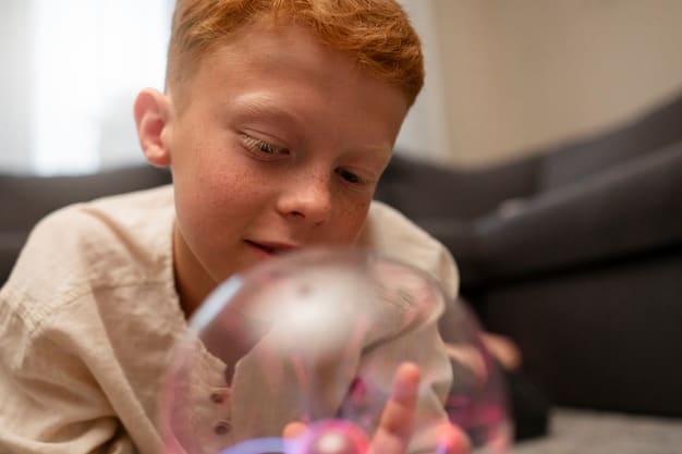 A young boy with autism is seated on the floor, fully engaged as he plays with a bubble tube, its gentle light and bubbles capturing his complete attention.