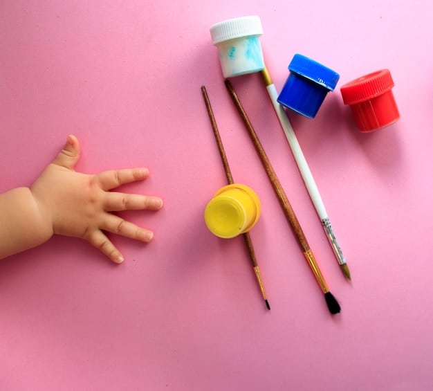 Close-up shot of a child's hands mixing different colors of paint on a palette with a paintbrush.