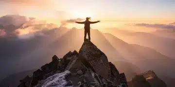 Person on a mountain peak at sunrise, symbolizing personal growth and peak performance